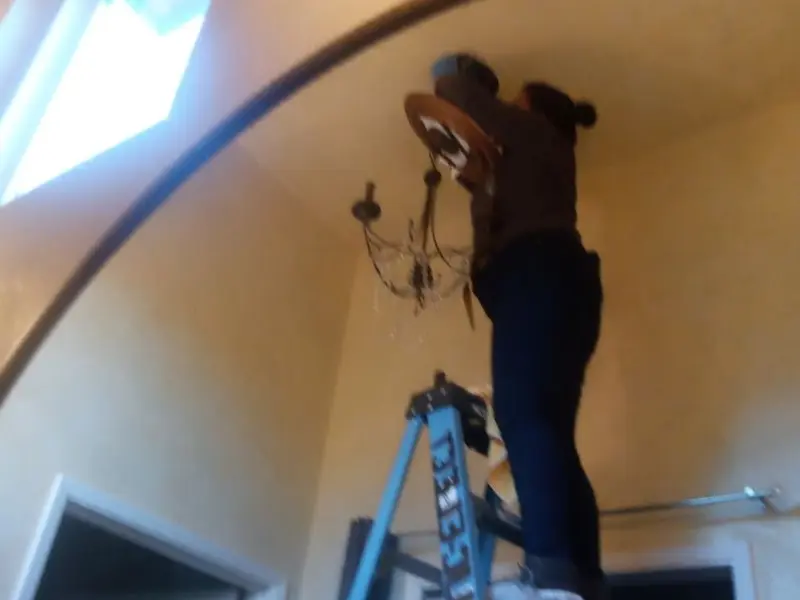Electrician installing a chandelier in a Hillsboro residence